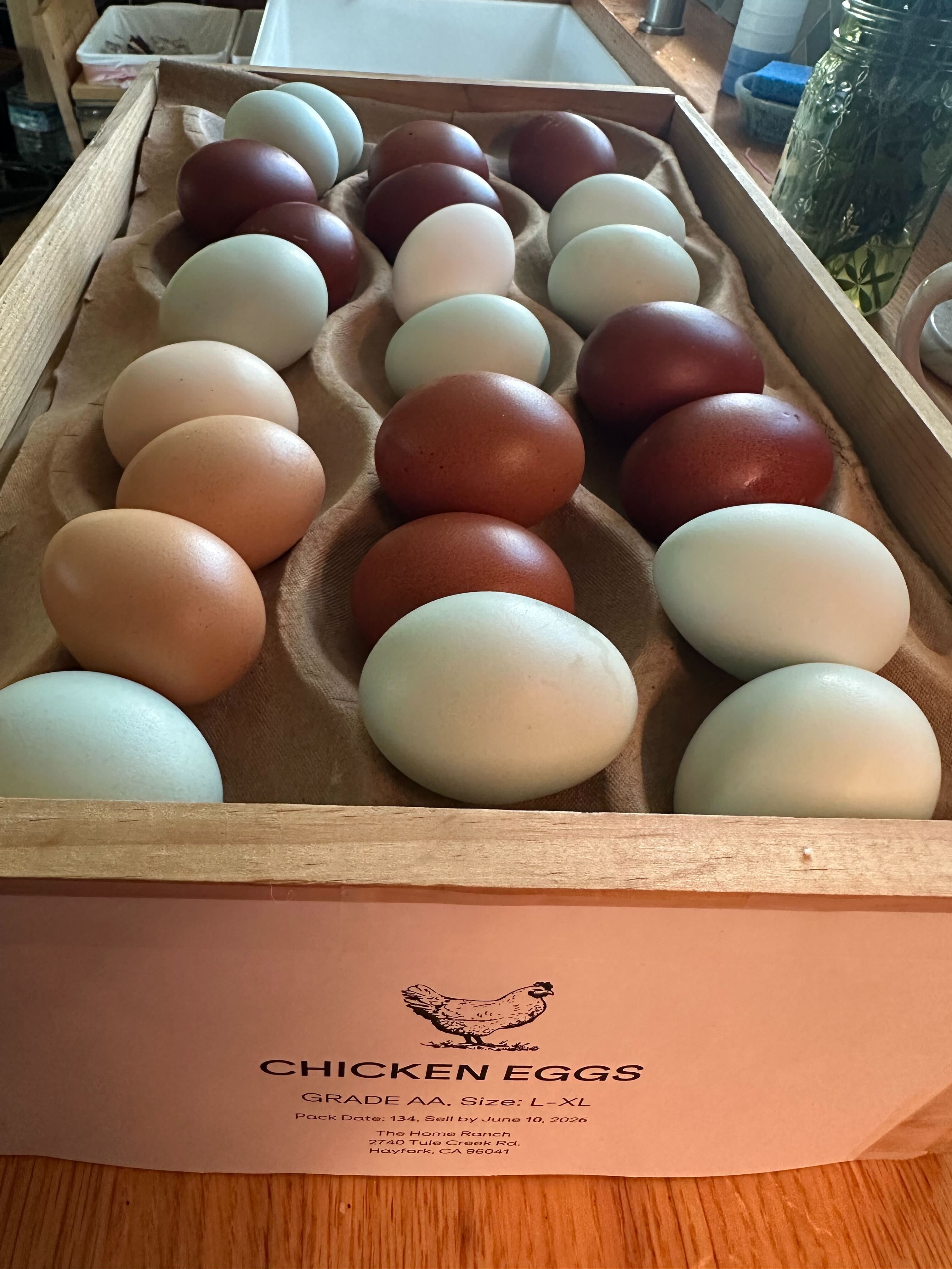 Colorful farm-fresh eggs in a wooden flat